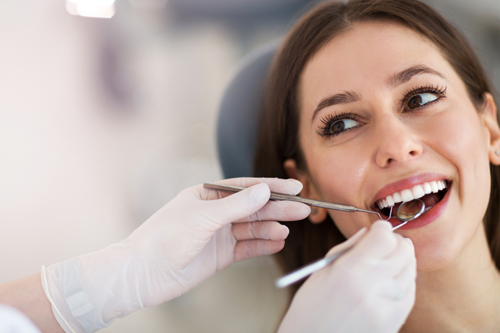 Woman during dental procedure with beautiful smile