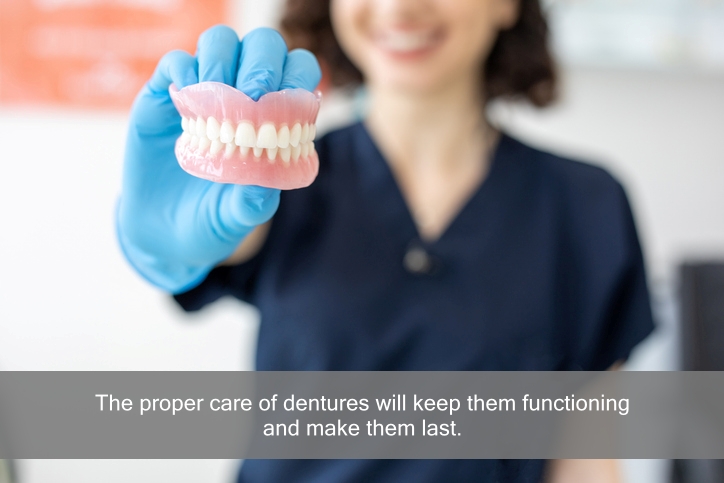 female dental hygienist holding dentures. Caption: The proper care of dentures with keep them functioning and make them last.