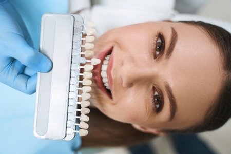 Young woman getting matched for dental veneers.